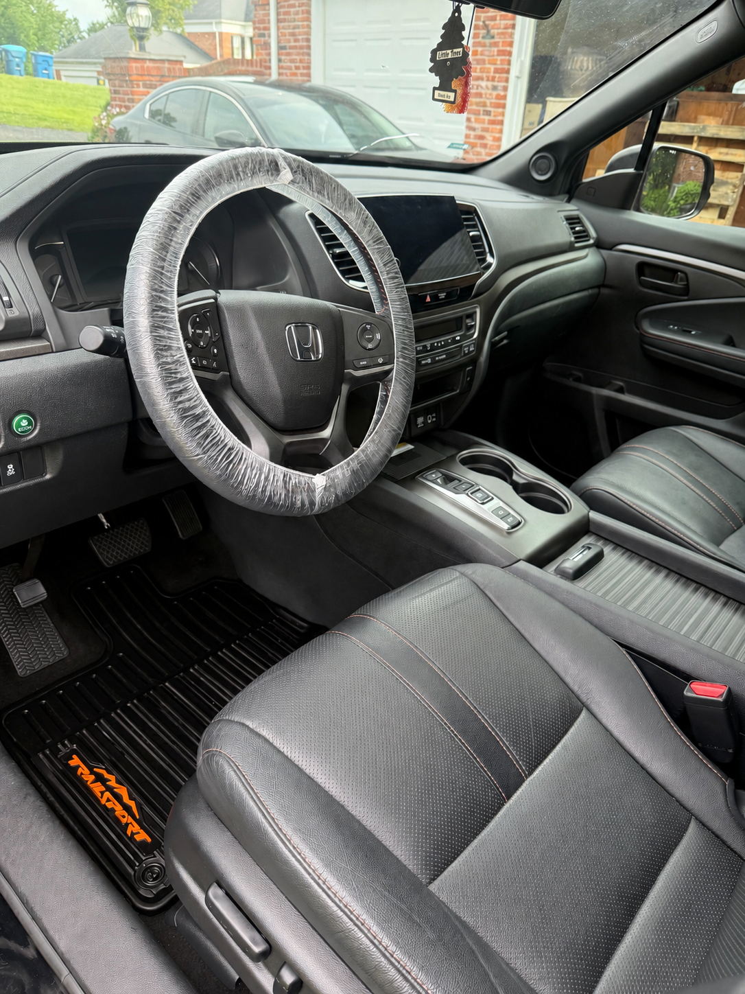 Freshly detailed Honda interior with a protected steering wheel and clean leather seats