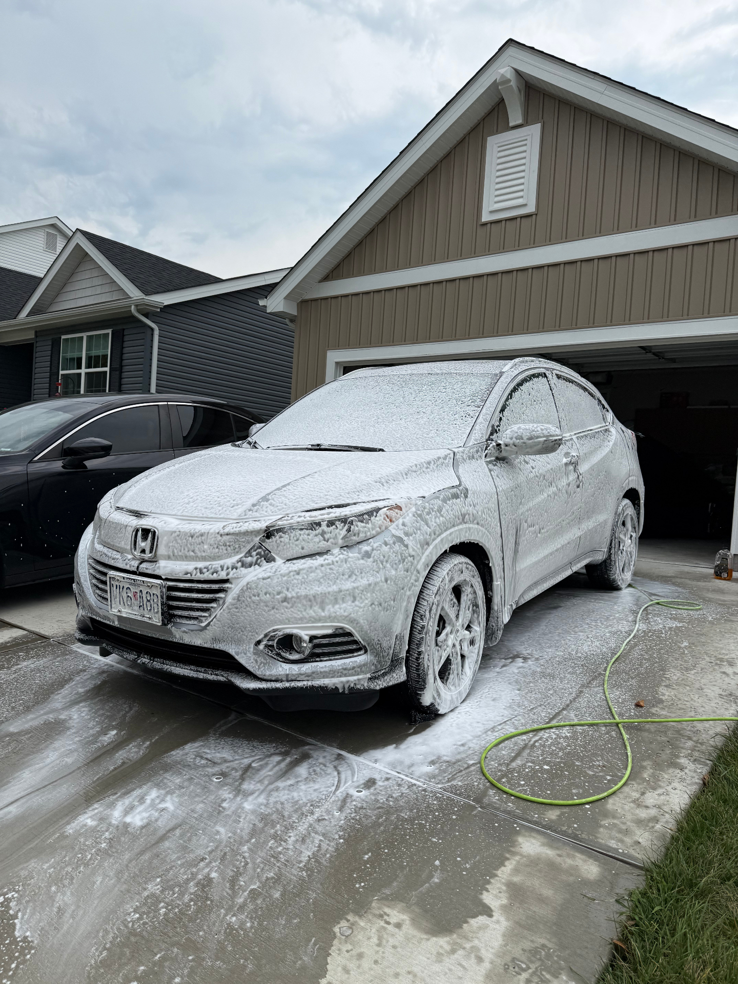 Honda HR-V covered in thick foam during an exterior wash in a St. Louis driveway